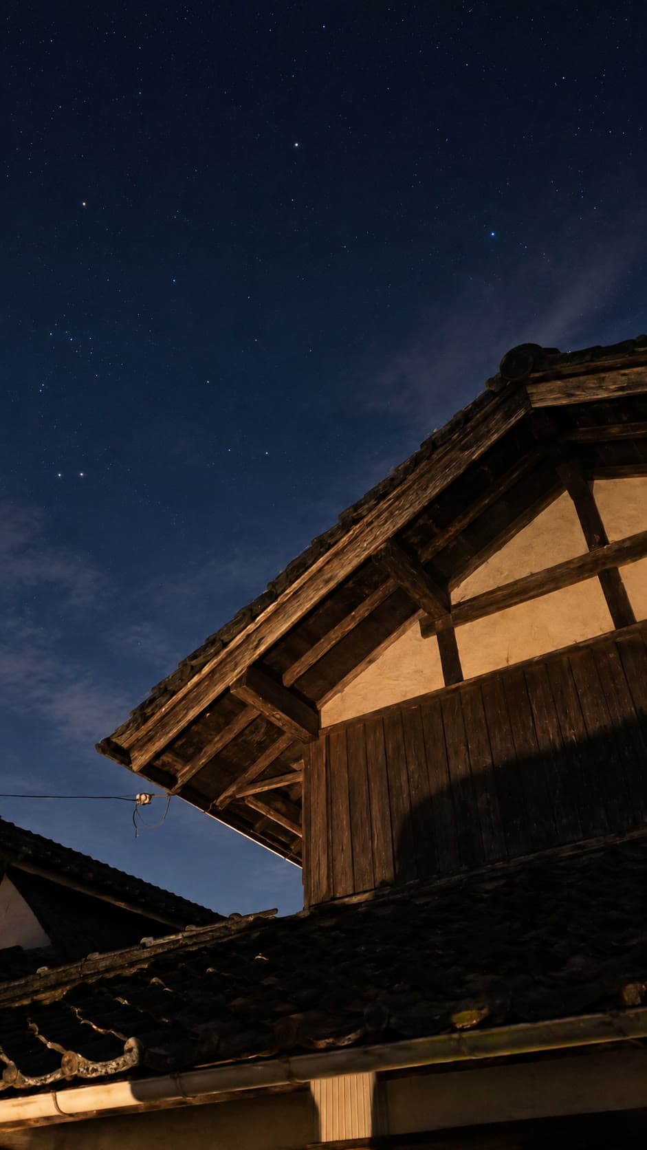満天の星の下に浮かぶ風山舎の古い木造屋根