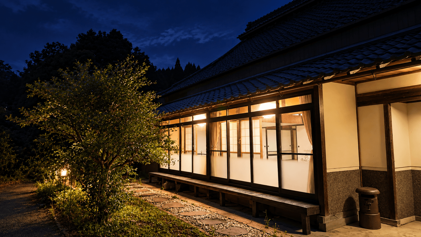 深い青の夜、縁側と室内に温かな灯りがともる風山舎